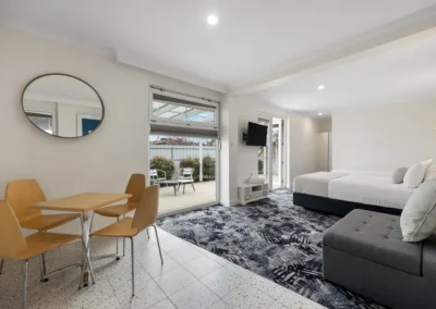 Deluxe Queen room with a private courtyard at Best Western Adelaide Airport Motel, featuring a comfortable queen bed, modern furnishings, and outdoor seating